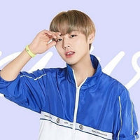 Person in a blue sports jacket with a pastel background.