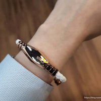 Person wearing a black and rose gold magnetic therapy bracelet, designed for pain relief and athletic performance by Clavis.
