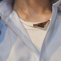 Person wearing Ares Ultra Strength Magnetic Therapy Necklace with black rose gold details by Clavis.
