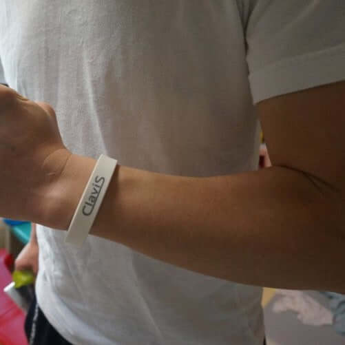 Person wearing Bonito Sports Ion Balance Energy Bracelet in white, showcasing Clavis logo and highlighting magnetic therapy features.