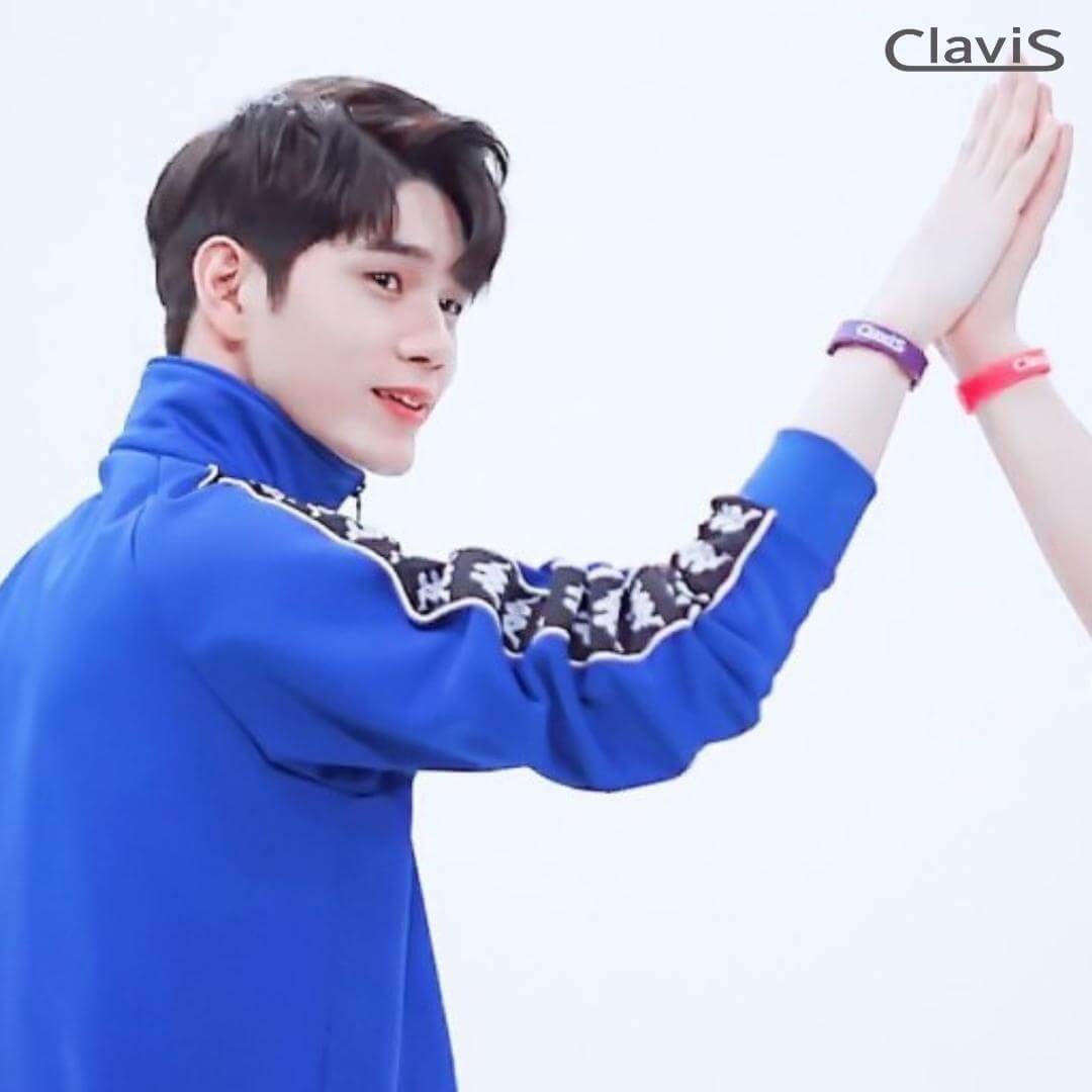 Person wearing Clavis athletic bracelet giving a high five, showcasing magnetic therapy benefits for sports performance.