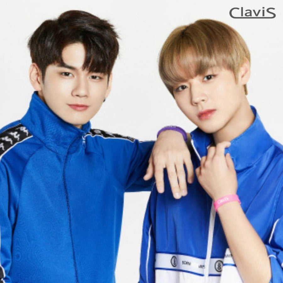 Two individuals wearing blue tracksuits and Clavis energy bracelets, promoting Korean wellness and athletic gear.