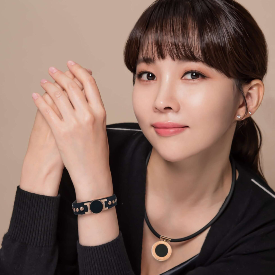 Woman wearing Onyx High Power Gauss Magnetic Therapy Necklace and Clavis athletic bracelet, Korean wellness and golf recovery gear.