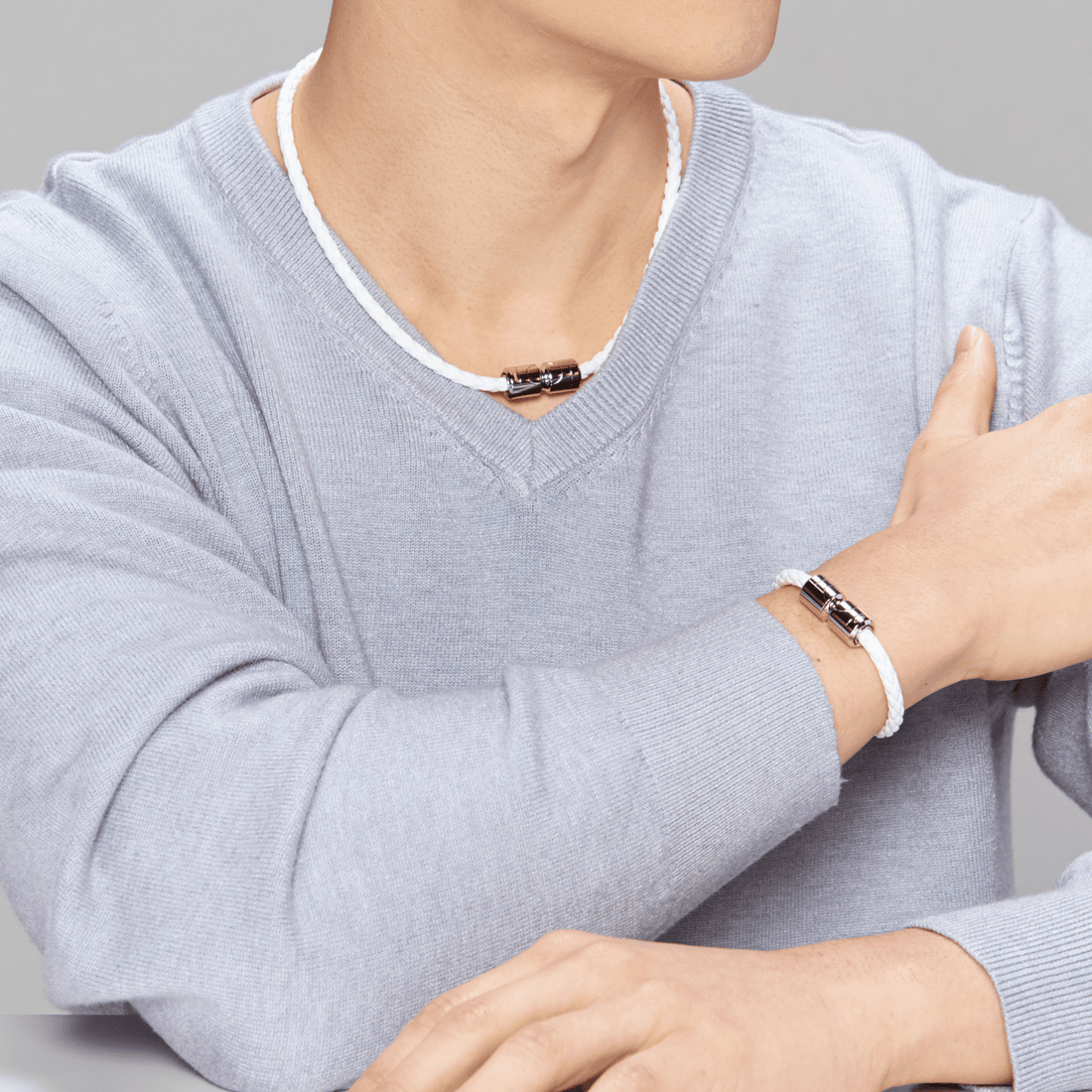 Man wearing Vita Ultra Strength Magnetic Therapy Bracelet, white band with rose gold clasp, promoting migraine and pain relief benefits.